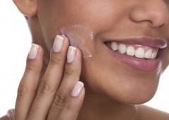 Young Woman Applying Cream On Her Face