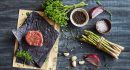 Raw tenderloin steak with seasoning, garlic, and asparagus
